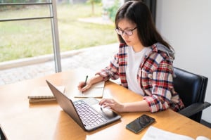 Young Asian female student working and studying from home