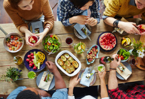 55722766 - intercultural friends eating tasty food by dinner